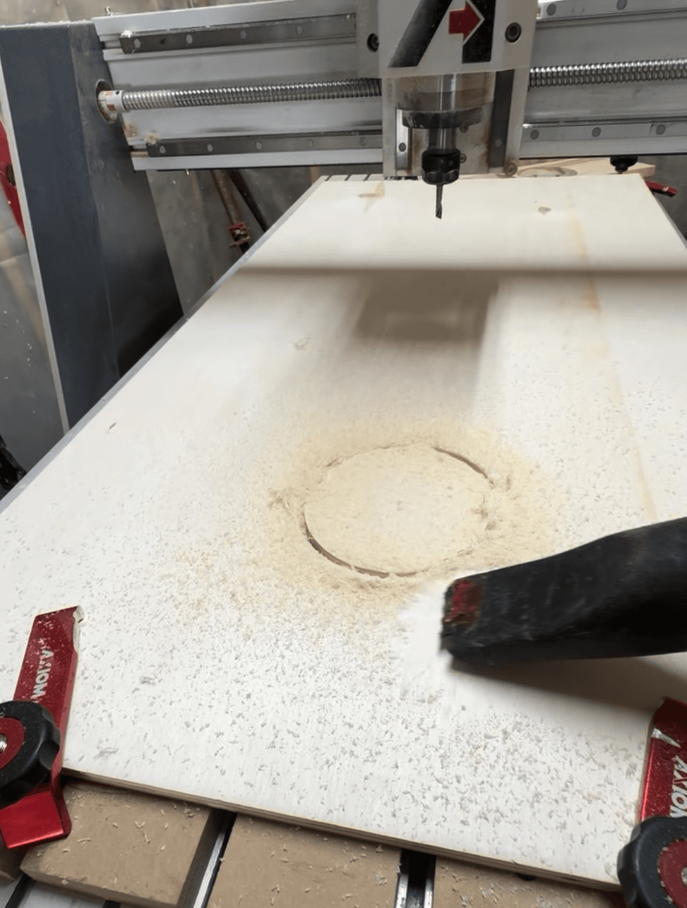 CNC machine cutting a perfect 6-inch hole through a birch plywood cornhole board