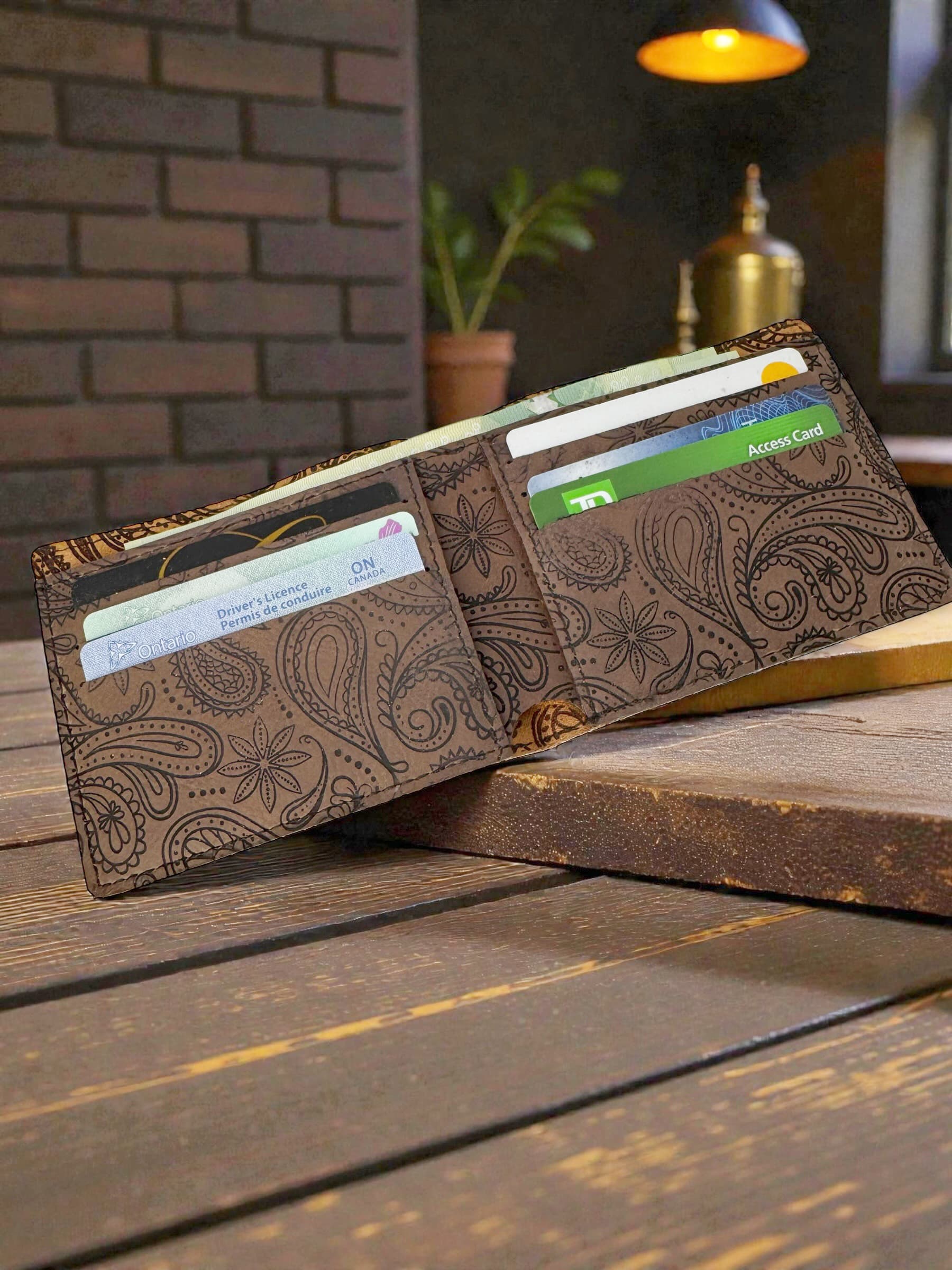 The engraved wallet open showing the interior with cards — a functional everyday piece