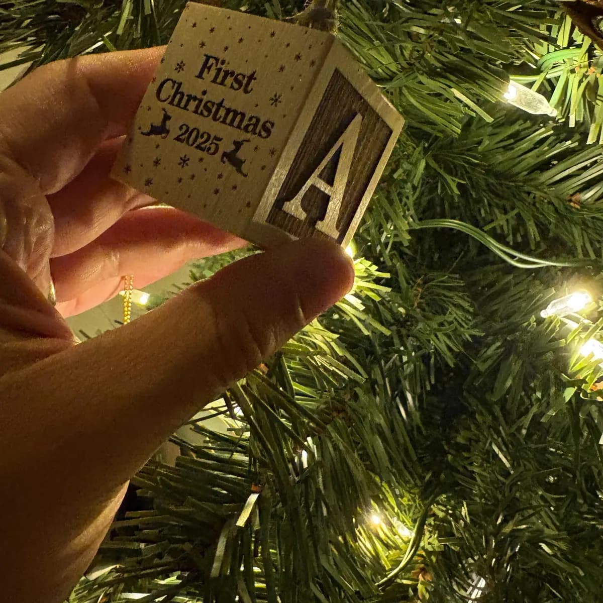 A maple baby keepsake block held in a hand for scale