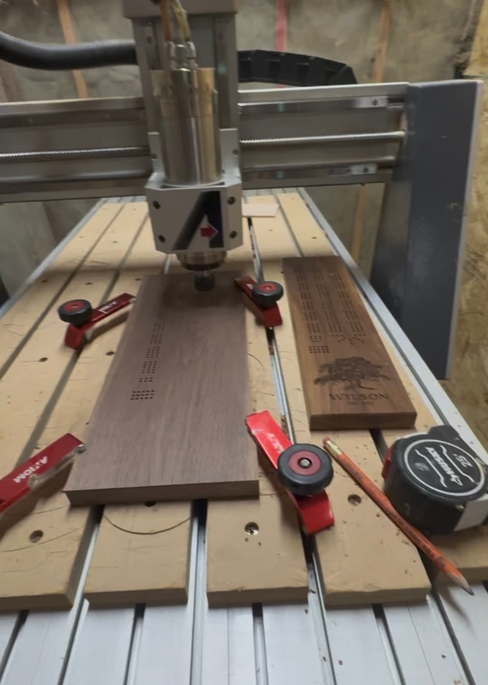 Kirk drilling the peg holes into a freshly milled cribbage board at the workshop bench