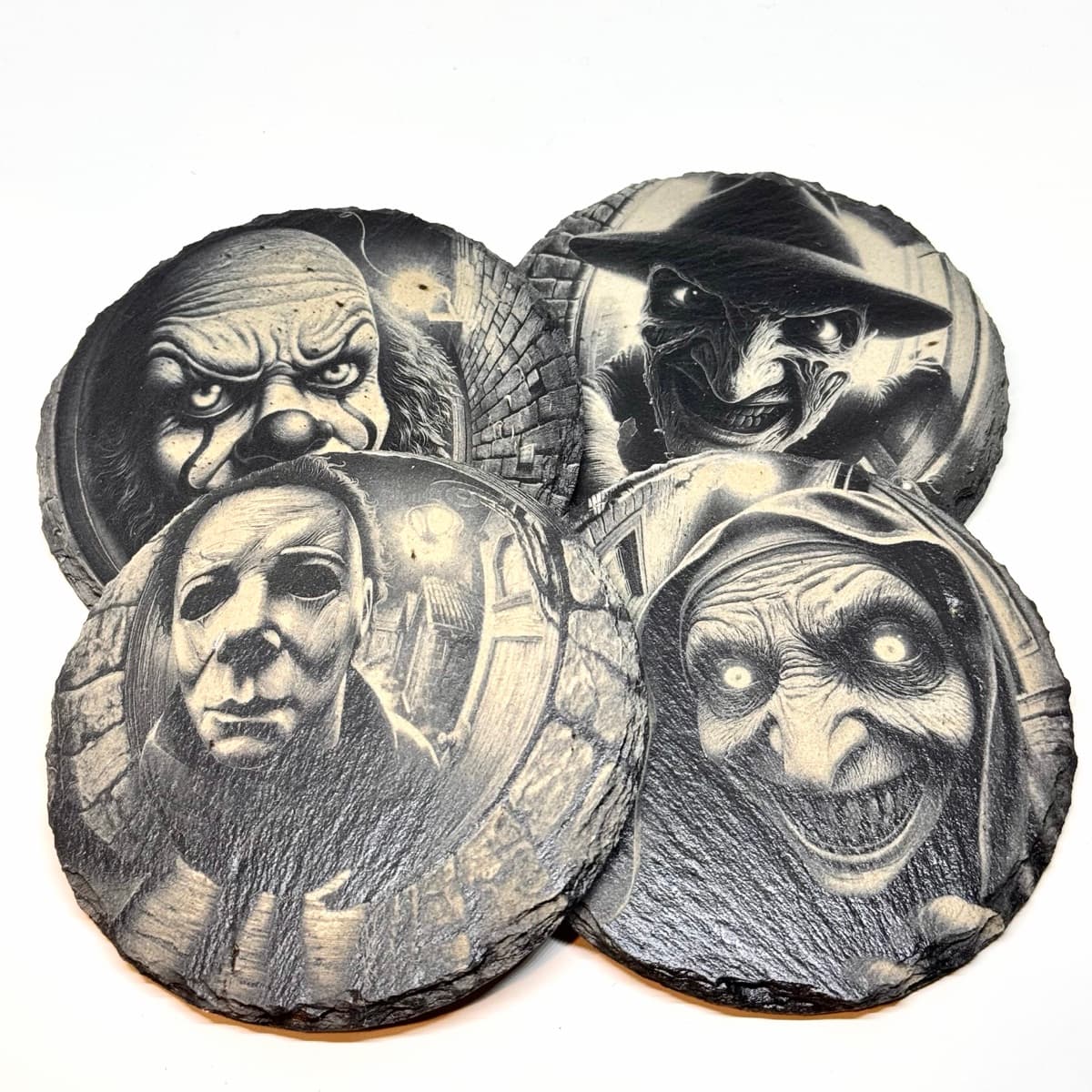 Four round slate coasters engraved with horror villains seen through a fisheye peephole