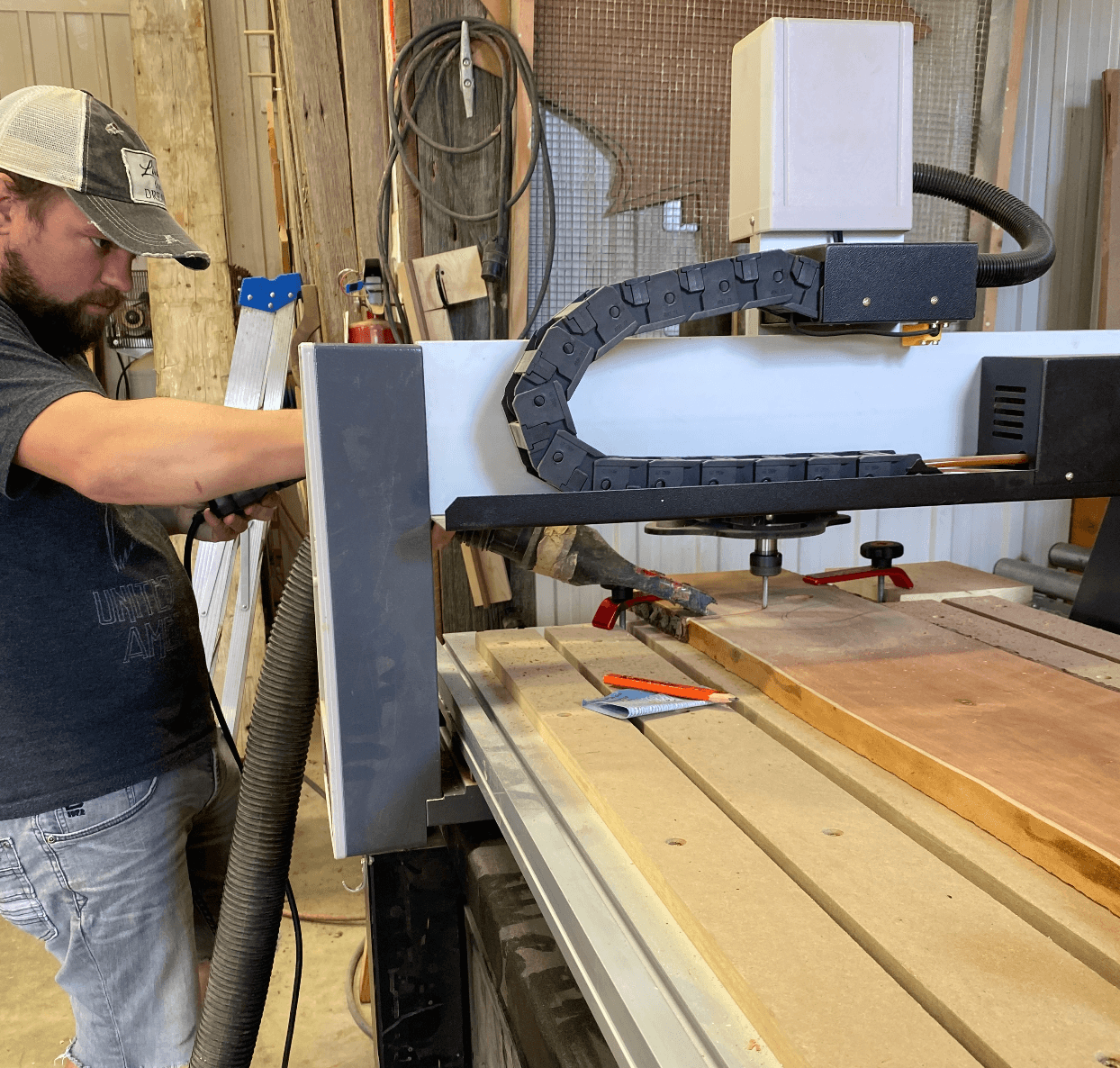 Kirk guiding the CNC machine as it cuts into a walnut slab