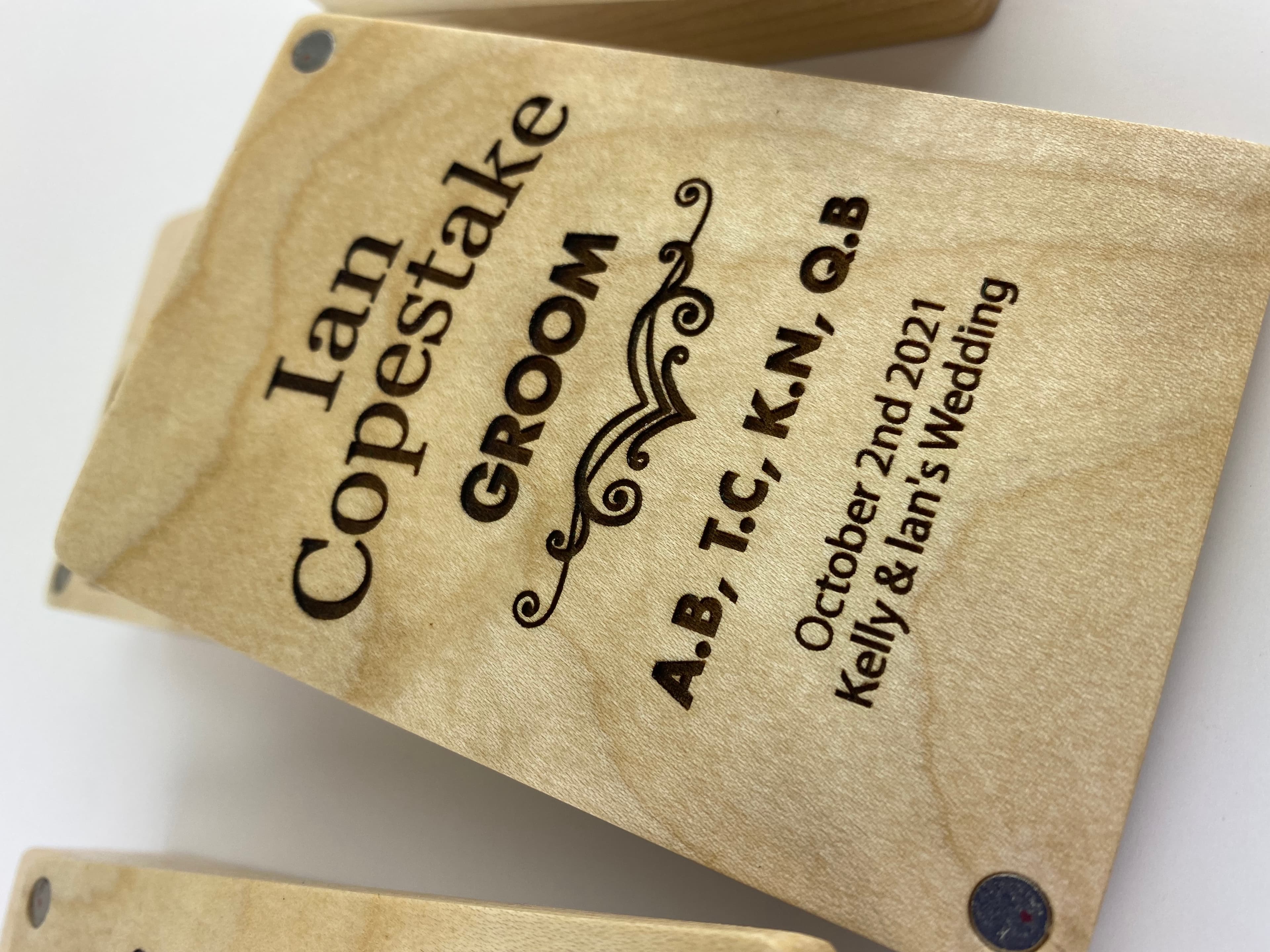 Close-up of engraved lid reading Ian Copestake, GROOM with wedding details and visible neodymium magnets