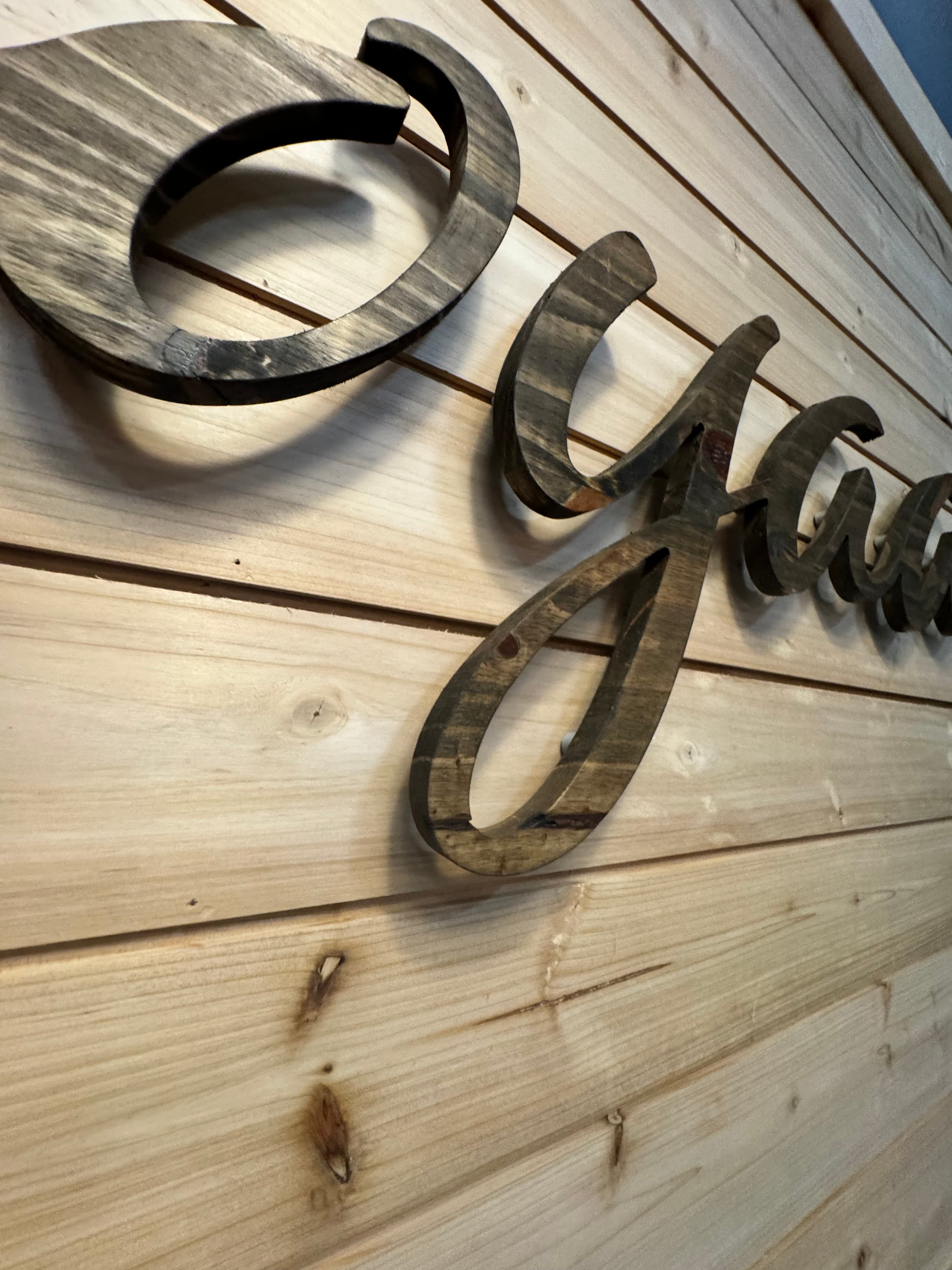 Close-up of CNC-cut wooden letters laid out on a workbench